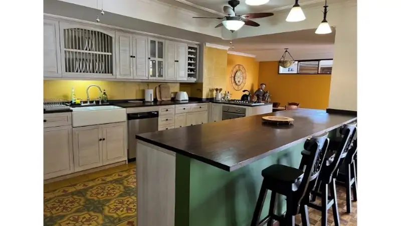 Modern rustic kitchen with island seating, wooden cabinetry, and warm lighting.