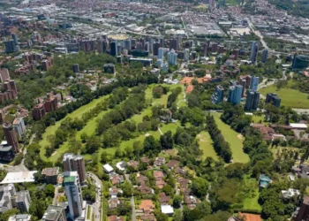Aerial shot of a downtown El Poblado in Medellin, Colombia with green-covered hills on background