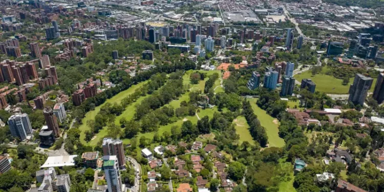 Aerial shot of a downtown El Poblado in Medellin, Colombia with green-covered hills on background