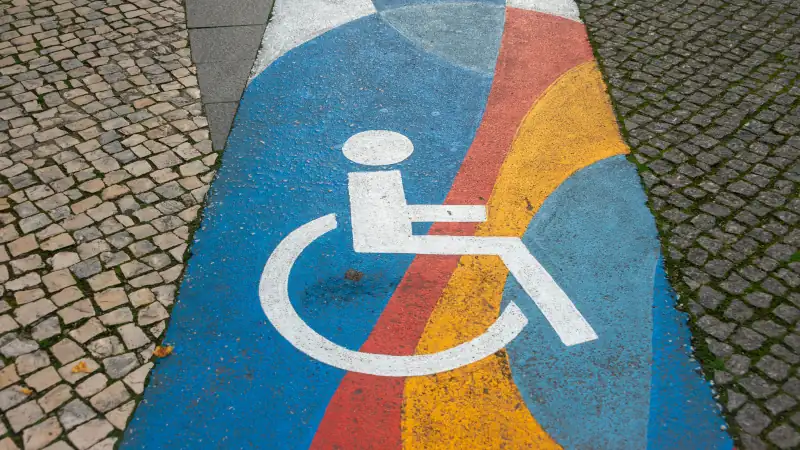 sign and path for disabled people through a cobblestone street