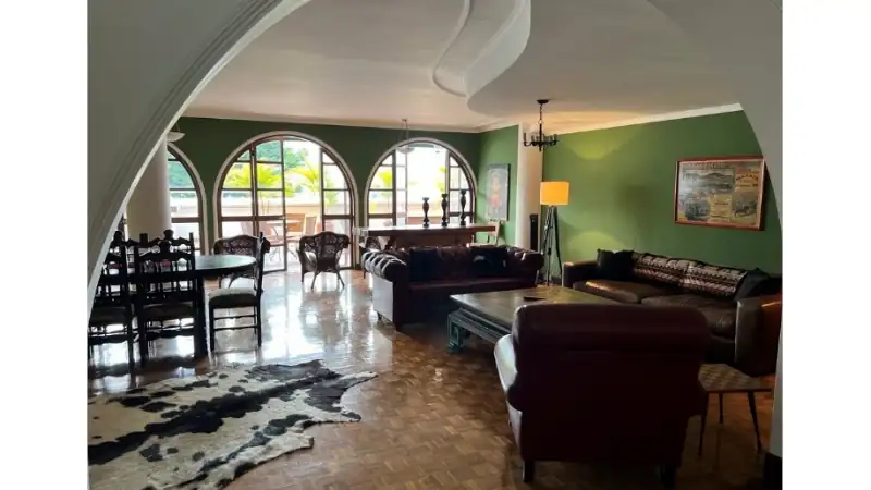 Spacious living room with arched windows, leather seating, and natural light.