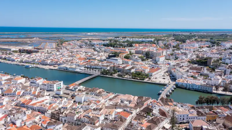 Tavira is shown from above with rivers, white buildings, and the Algarve coast visible.