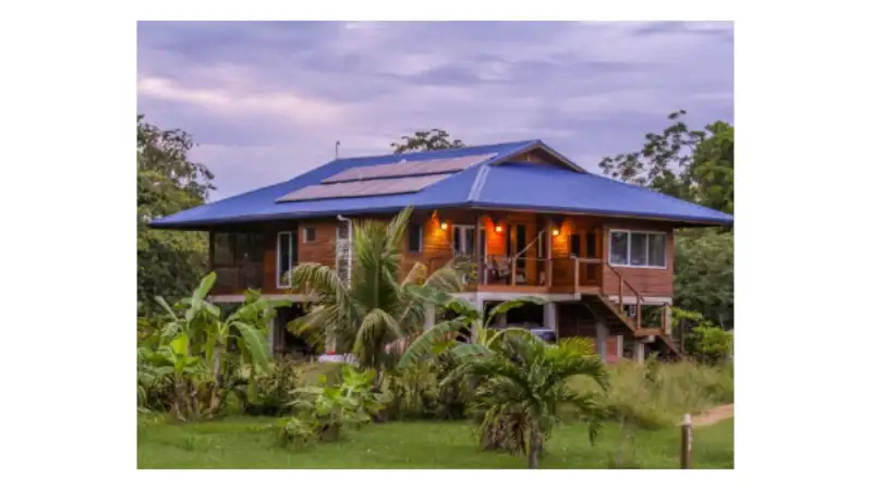 Charming elevated wooden home surrounded by tropical greenery in the Cayo District, Belize.