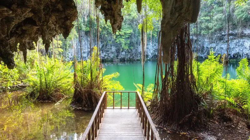 Scenic view of limestone cave, beautiful lake and tropical plants, nature landscape, outdoor travel background