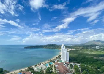 Aerial view of a beachfront resort along Panama’s Pacific coast, with tropical greenery, turquoise waters, and a white luxury tower beside the beach.
