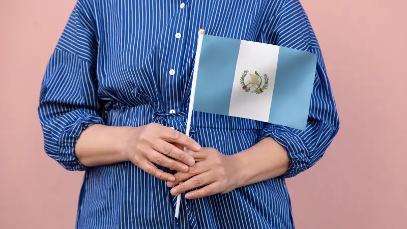 Guatemalan flag held by hands, symbolizing national pride