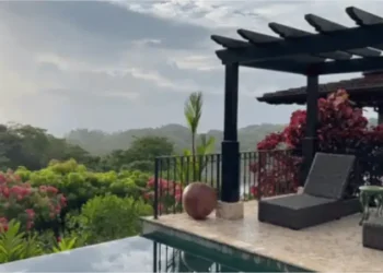 A peaceful terrace at Los Islotes featuring lounge chairs beside an infinity pool, surrounded by tropical gardens and overlooking a lush, misty landscape.