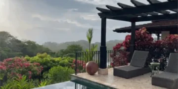 A peaceful terrace at Los Islotes featuring lounge chairs beside an infinity pool, surrounded by tropical gardens and overlooking a lush, misty landscape.