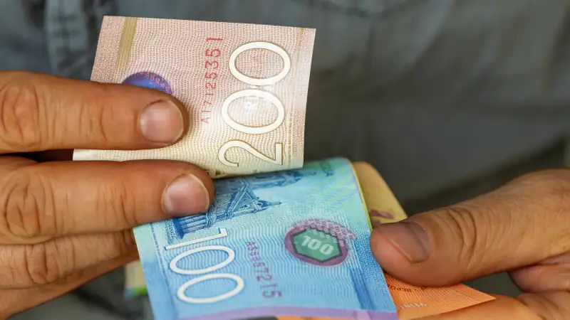 Man counting Nicaraguan Córdoba banknotes and coins