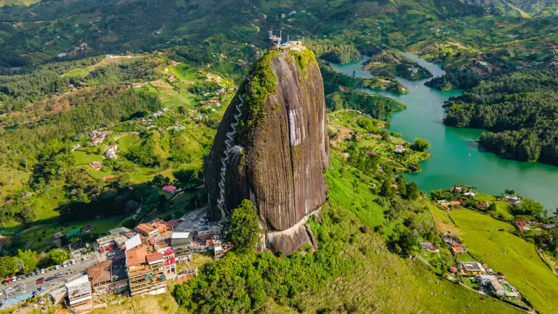 Aerial View of El Peñol Rock in Guatape, Antioquia, Colombia Surrounded by Lush Green Landscape and Lake