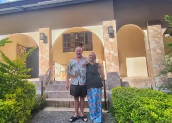 Gabrielle and Patrick Reynolds standing outside their tropical-style home surrounded by lush greenery in Boquete.