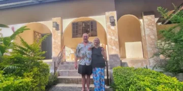 Gabrielle and Patrick Reynolds standing outside their tropical-style home surrounded by lush greenery in Boquete.