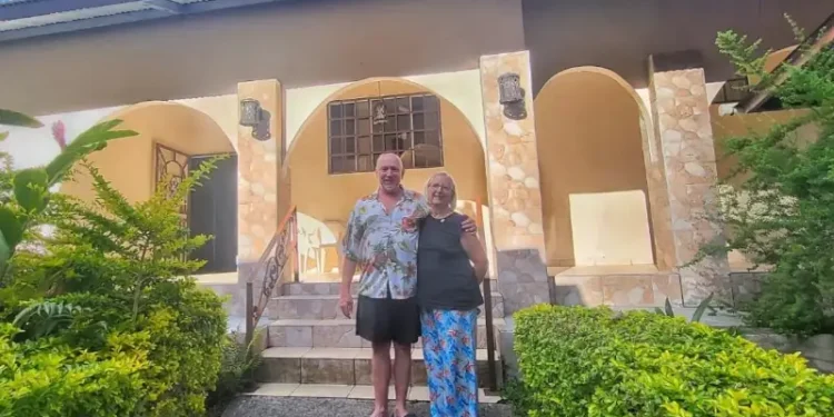 Gabrielle and Patrick Reynolds standing outside their tropical-style home surrounded by lush greenery in Boquete.