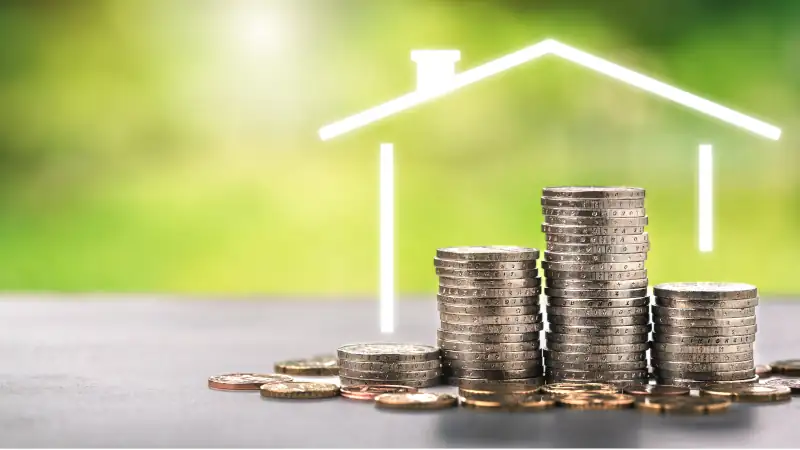 House outline over stacked coins representing property value and investment in Uruguay