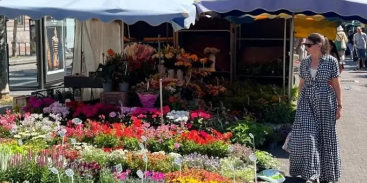 Kathleen browsing colorful flower stalls at an outdoor market in Strasbourg, France.