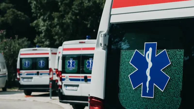 Multiple white ambulance vans parked together in Split, Croatia amid the coronavirus pandemic. Global healthcare symbol on their door windows