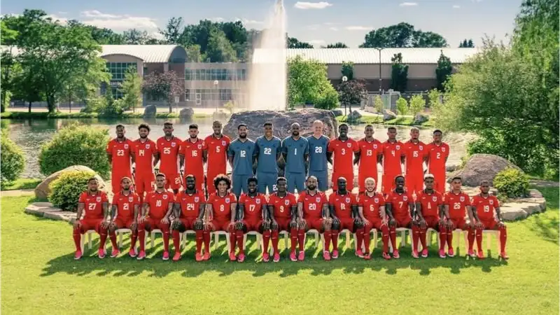 Official team photo of the Panama men's national soccer team posing outdoors in red uniforms beside a lake and fountain during a training camp or tournament.