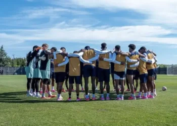 Panama national soccer team players gather in a pre-training huddle on a practice field, preparing for an upcoming match during an international tournament.