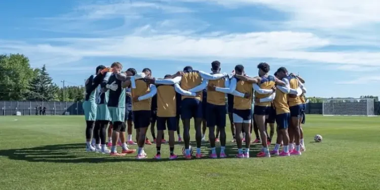 Panama national soccer team players gather in a pre-training huddle on a practice field, preparing for an upcoming match during an international tournament.