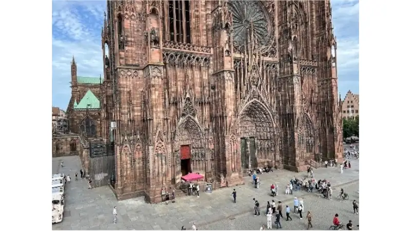 Strasbourg Cathedral's towering Gothic façade overlooking the lively square in the heart of Strasbourg, France.