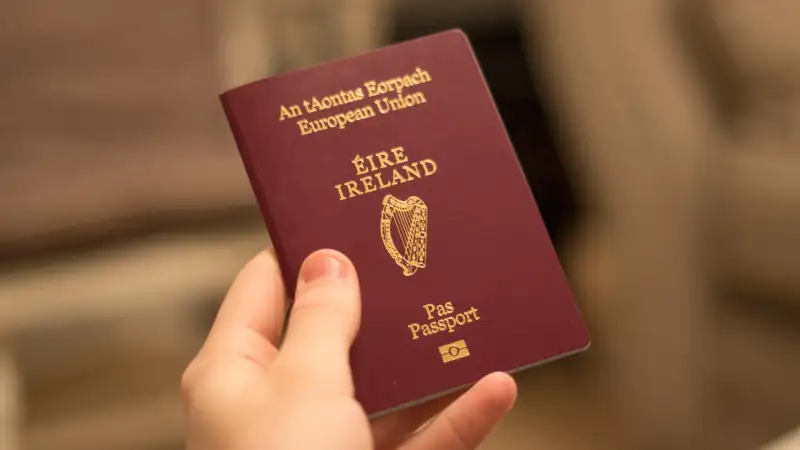 Hand holding an Irish passport, symbolizing citizenship or residency