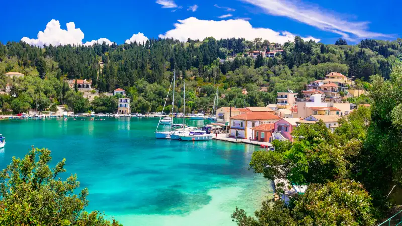 Lakka Village Panorama in Paxos Island Greece. Turquoise bay of Ionian Sea with sailing boats and yachts
