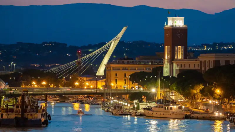 The view in the dusk from Ponte del Mare monumental bridge in the canal and port of Pescara city, Abruzzo region.