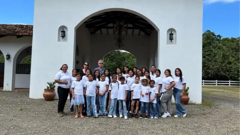 Group photo in front of the ranch entrance during a community visit, highlighting the welcoming atmosphere and family-friendly environment.