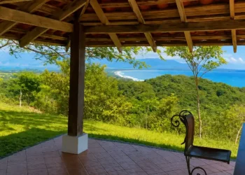 Rustic open-air terrace overlooking the lush coastline and turquoise waters of Los Islotes, Panama, with mountains and tropical forest stretching into the distance.