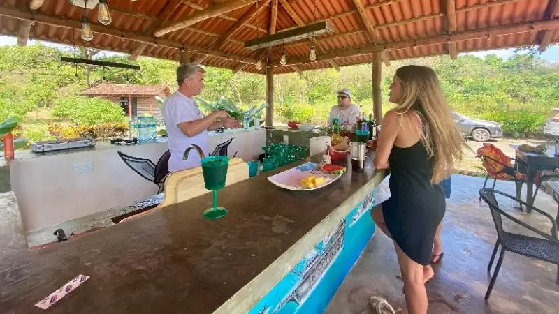 Relaxed open-air bar overlooking the pool, with guests enjoying drinks and snacks.