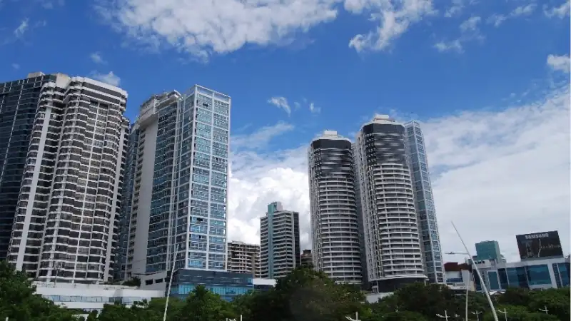 Modern Panama City skyline featuring tall residential and commercial towers beneath a blue sky.