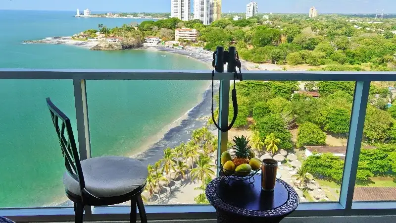 Panoramic coastal view of Panama from a high-rise balcony overlooking the beach and ocean.