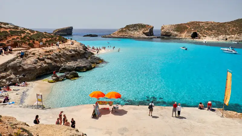 People enjoy blue lagoon with crystal clear blue water.