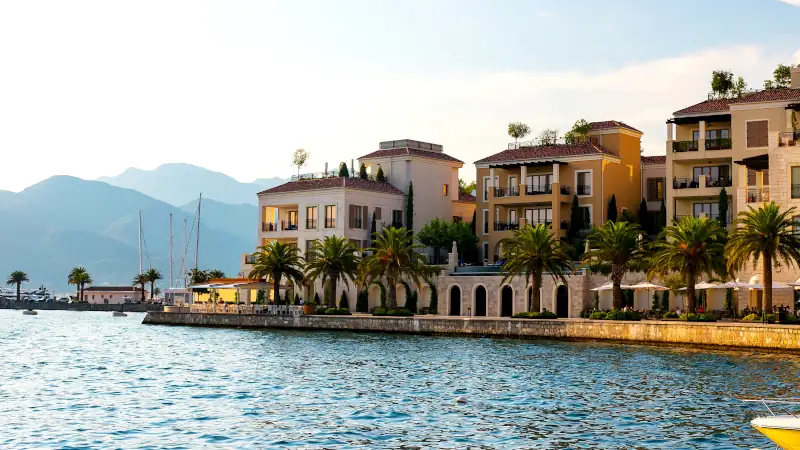 Scenic panoramic view of the historical city of Tivat, located in the Bay of Kotor on a sunny day at sunset in summer, the water reflects the rays of the sun, Montenegro