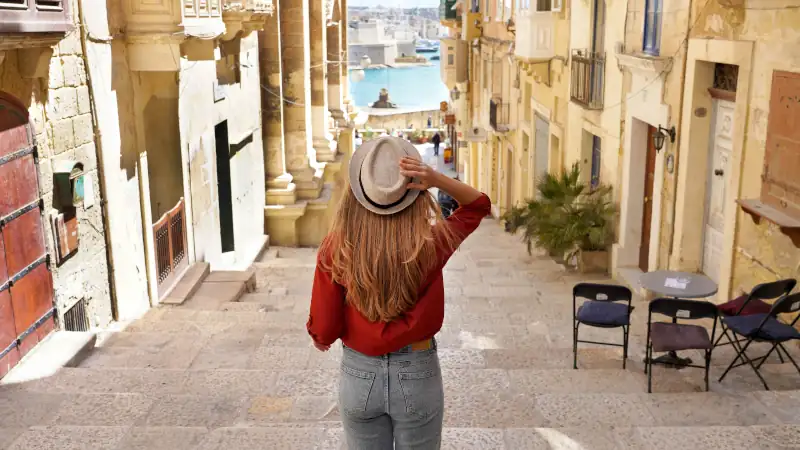 Woman descending stairs in the historic city of Valletta, Malta.