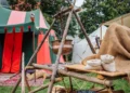 Medieval Festival Camp Scene With Colorful Tent Open Fire Pit And Wooden Table Setup Historical Reenactment Outdoor Living Exhibit