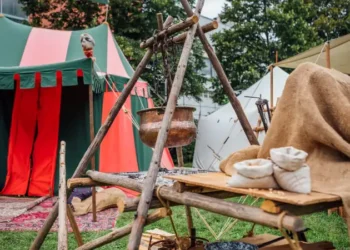 Medieval Festival Camp Scene With Colorful Tent Open Fire Pit And Wooden Table Setup Historical Reenactment Outdoor Living Exhibit