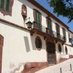 Colonial architecture on a steep cobbled street in Portugal.