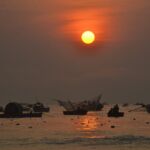 The sun sets over Vietnamese fishing boats.