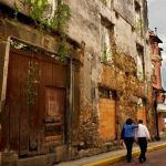 San Felipe, also known as Casco Viejo, area in Panama City, Panama. Skeletons of old 17 Century buildings with plants growing from its walls contrast with well keep Church down the street. Panama Casco Viejo