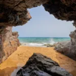 Cave by the sea and girl taking a bath. Calblanque Regional Park in Murcia