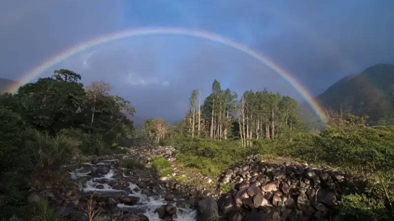 Tropical landscape image showing a river framed by a double rainbow after a rainstorm. Image taken in Boquete, Panama.
