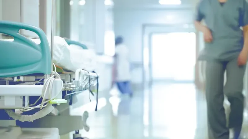 A Doctor Walking past a bed