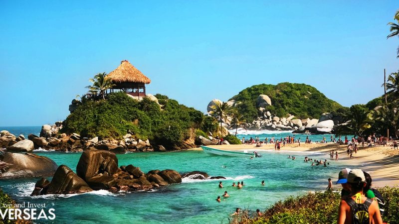 a popular beach with rocks and hills in colombia