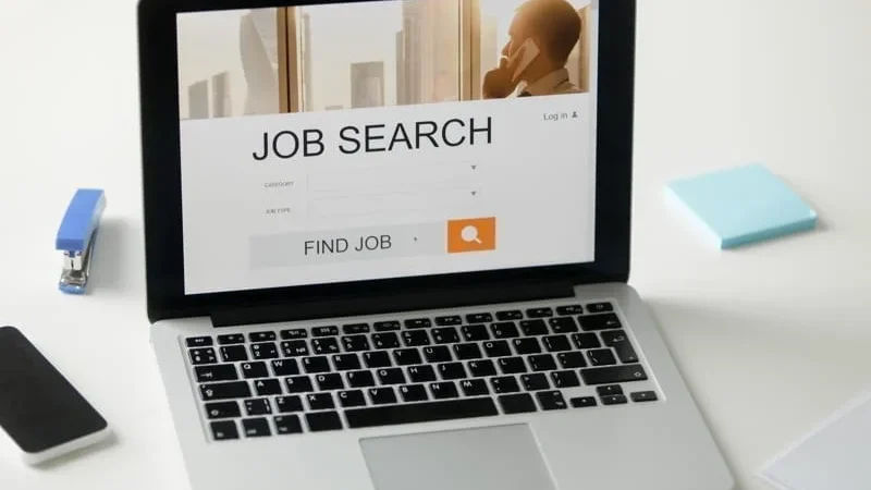 Open laptop on the desk, job search title on screen. work in colombia